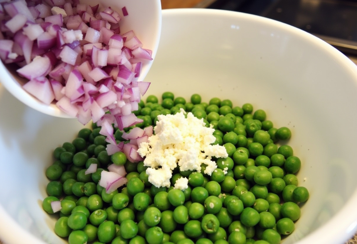 Adding red onion and feta cheese to peas for Spring Pea Salad.