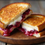 Delicious Cranberry Brie & Mozzarella Grilled Sandwich with melted cheese and cranberries.