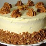 Finished Delicious Carrot Cake with cream cheese frosting and walnuts, ready to serve.