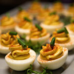 Gourmet Deviled Eggs with a Twist garnished with chives and smoked paprika.