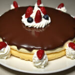 Finished No-Bake Eclair Cake with chocolate glaze and whipped cream, perfect for dessert.