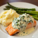 Finished pan-fried salmon with creamy Florentine sauce, a gourmet dinner dish.