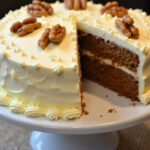 Finished Traditional Carrot Cake with cream cheese frosting and walnuts, ready to serve.