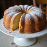 Finished vintage cake with powdered sugar on a cake stand.