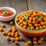 Final presentation of perfectly roasted chili chickpeas, a healthy and crunchy snack with herbs and sauce.