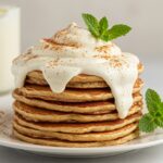 Delicious Cinnamon Roll Pancakes display with cream cheese frosting and cinnamon, perfect for breakfast.