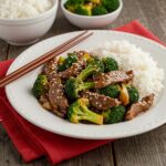 Delicious Easy Beef and Broccoli Recipe served in a bowl with rice, inviting dinner setting, perfect meal for families and gatherings.