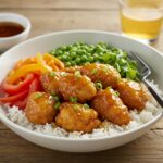 Final presentation of a Hot Honey Chicken Bowl with crispy chicken, rice, and fresh veggies, perfect for a healthy meal.