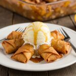 Delicious Peach Cobbler Egg Rolls served on a plate with vanilla ice cream and caramel, a delightful dessert that perfectly balances flavors.