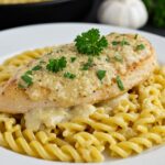 Delicious Creamy Garlic Parmesan Chicken served over cheesy twisted pasta, a perfect comfort food dish.